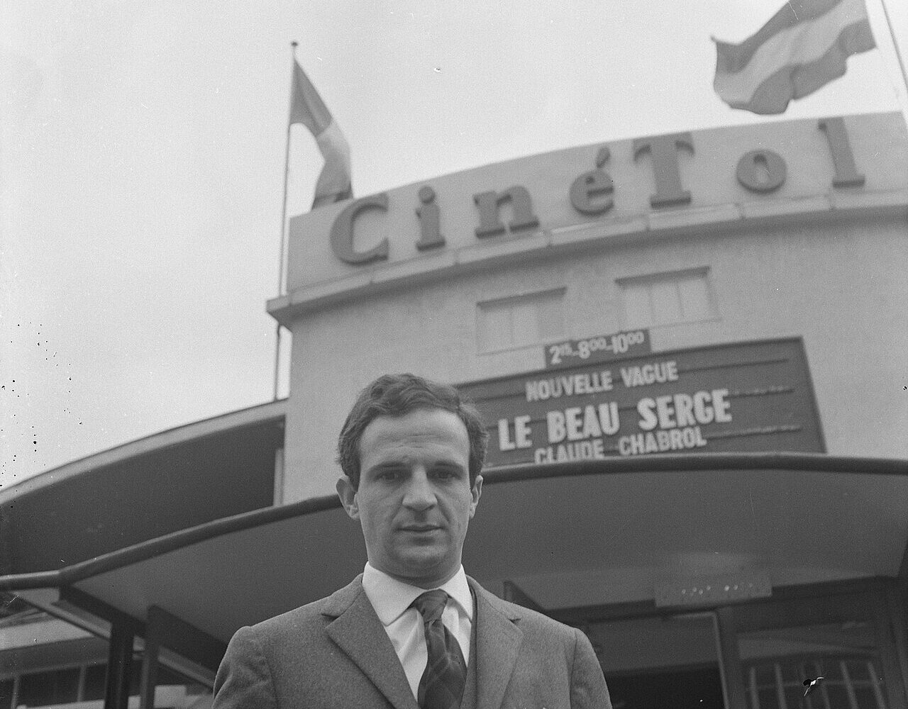 François Truffaut devant un cinéma, sous une affiche de la Nouvelle Vague