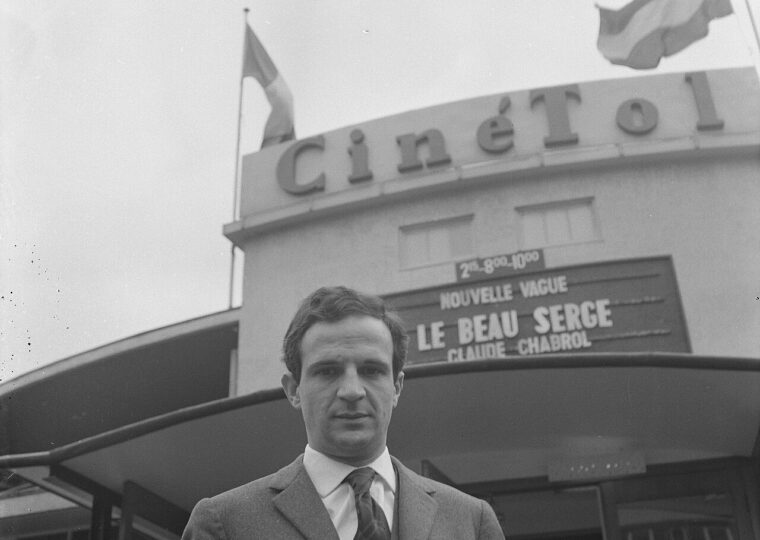 François Truffaut devant un cinéma, sous une affiche de la Nouvelle Vague