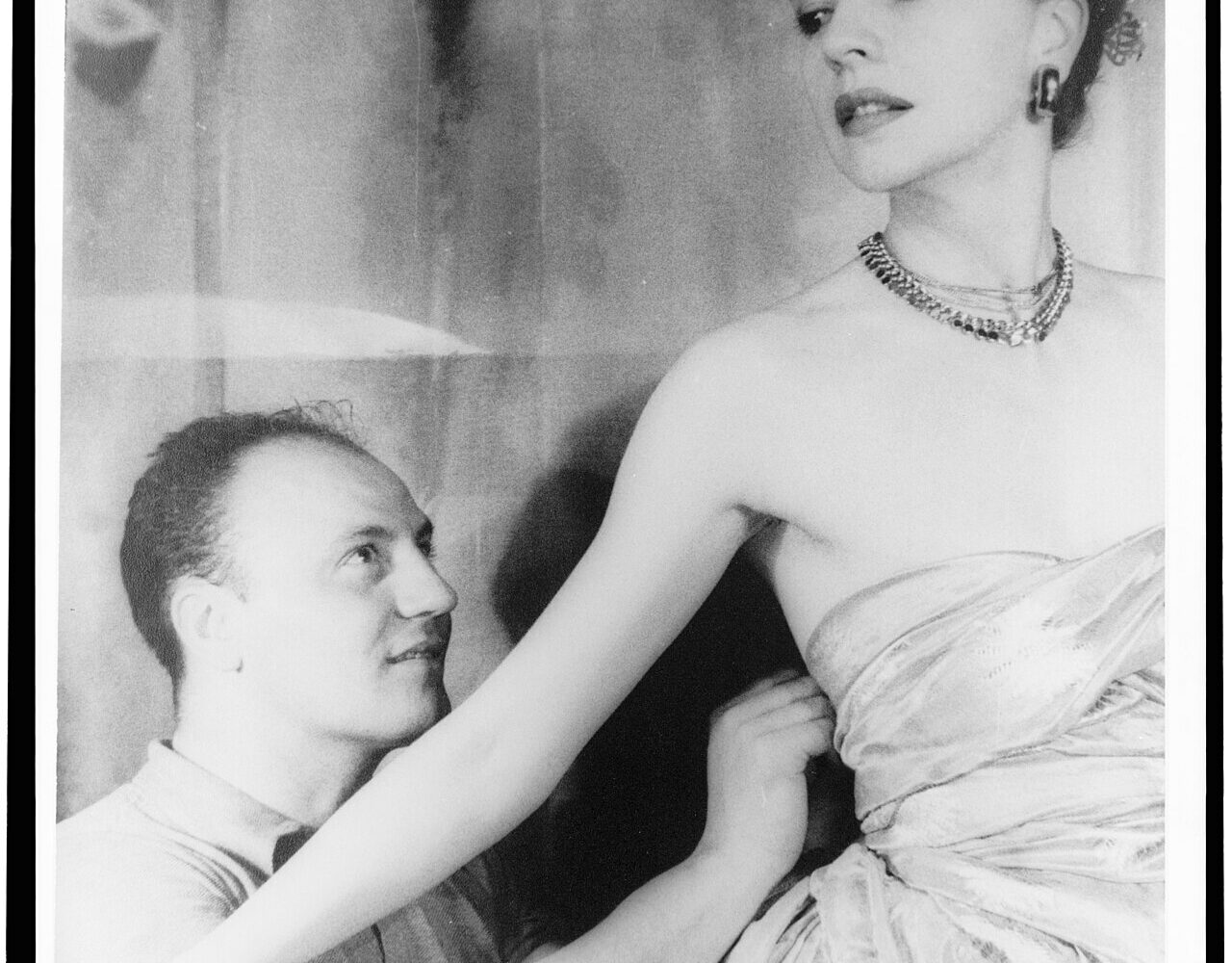 Pierre Balmain travaillant une robe dans son atelier parisien