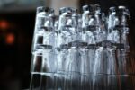 Verres de bar empilés en pyramide sur un comptoir sombre