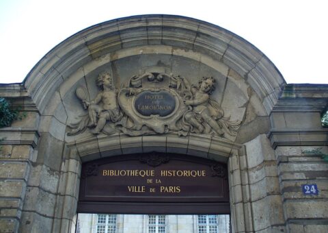 Le fronton sculpté du portail de l'hôtel de Lamoignon, avec l'enseigne de la Bibliothèque historique de la Ville de Paris