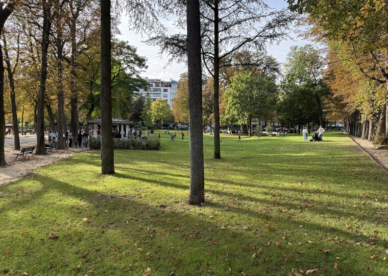 Les pelouses du jardin du Ranelagh sous les arbres à l'automne, un kiosque de confiseries au fond