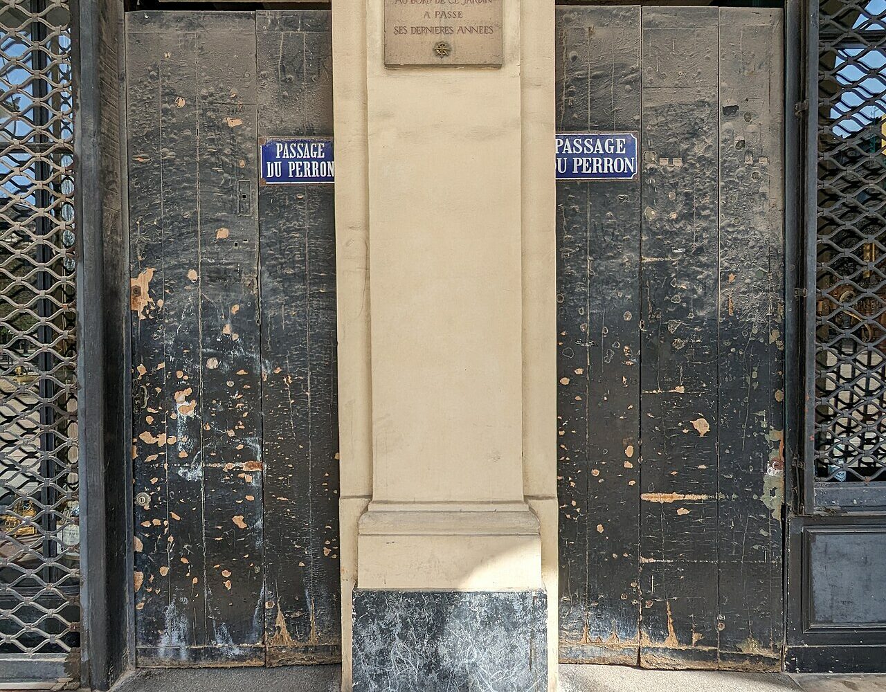 Les portes du passage du Perron sous la galerie de Beaujolais, avec la plaque rappelant que Colette vécut dans l'immeuble