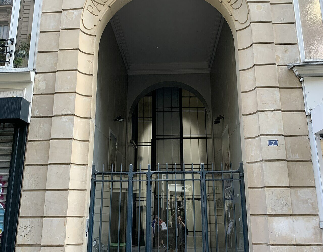 Le portail clos du passage Ben-Aïad, avec son arche gravée, vu depuis la rue Léopold-Bellan