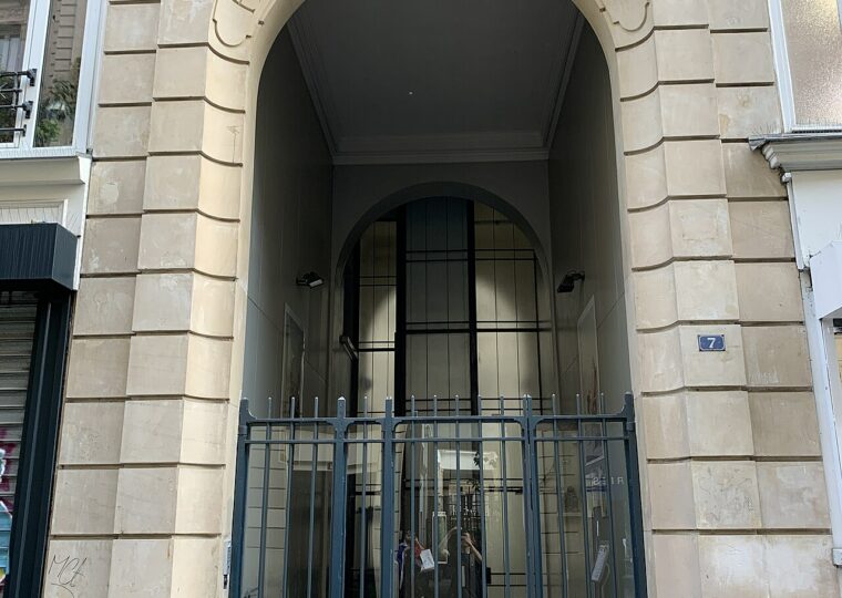 Le portail clos du passage Ben-Aïad, avec son arche gravée, vu depuis la rue Léopold-Bellan