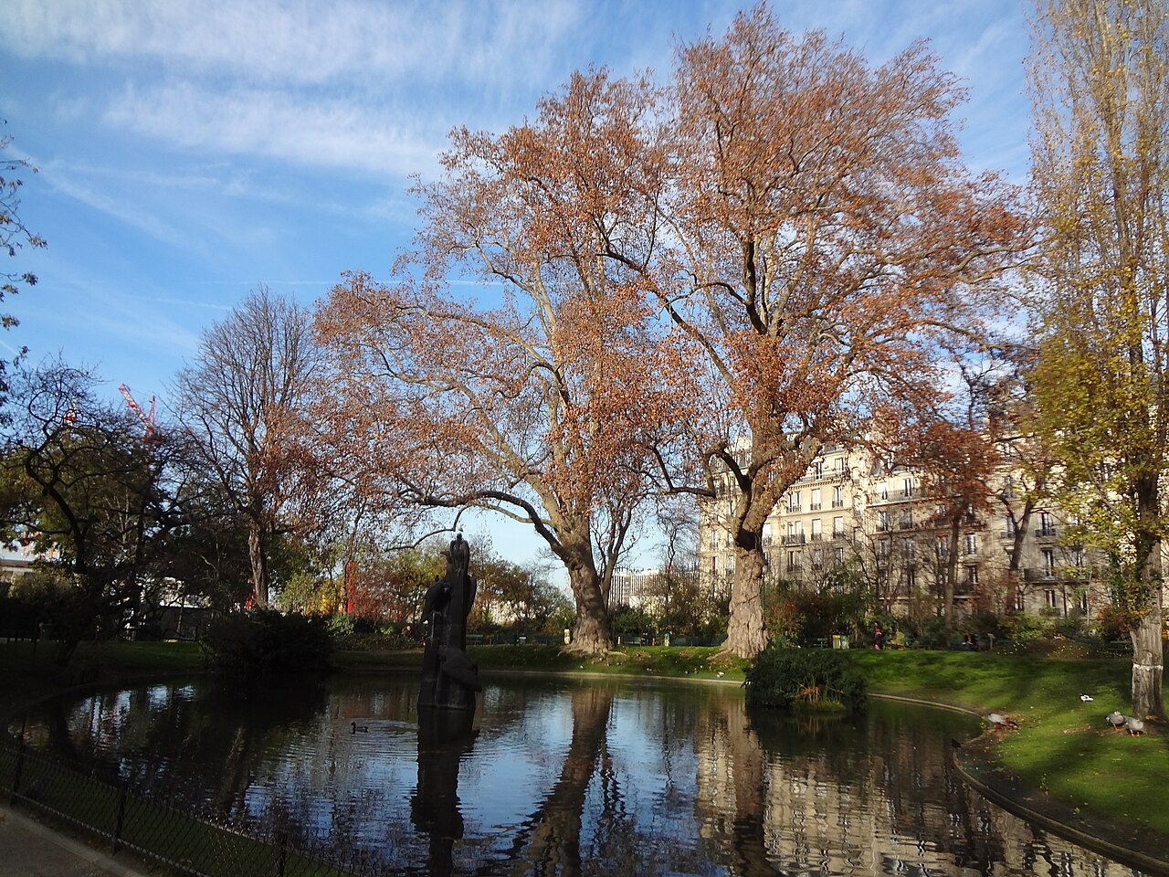 Le bassin du square des Batignolles en automne, ses canards et la sculpture des Vautours au bord de l'eau
