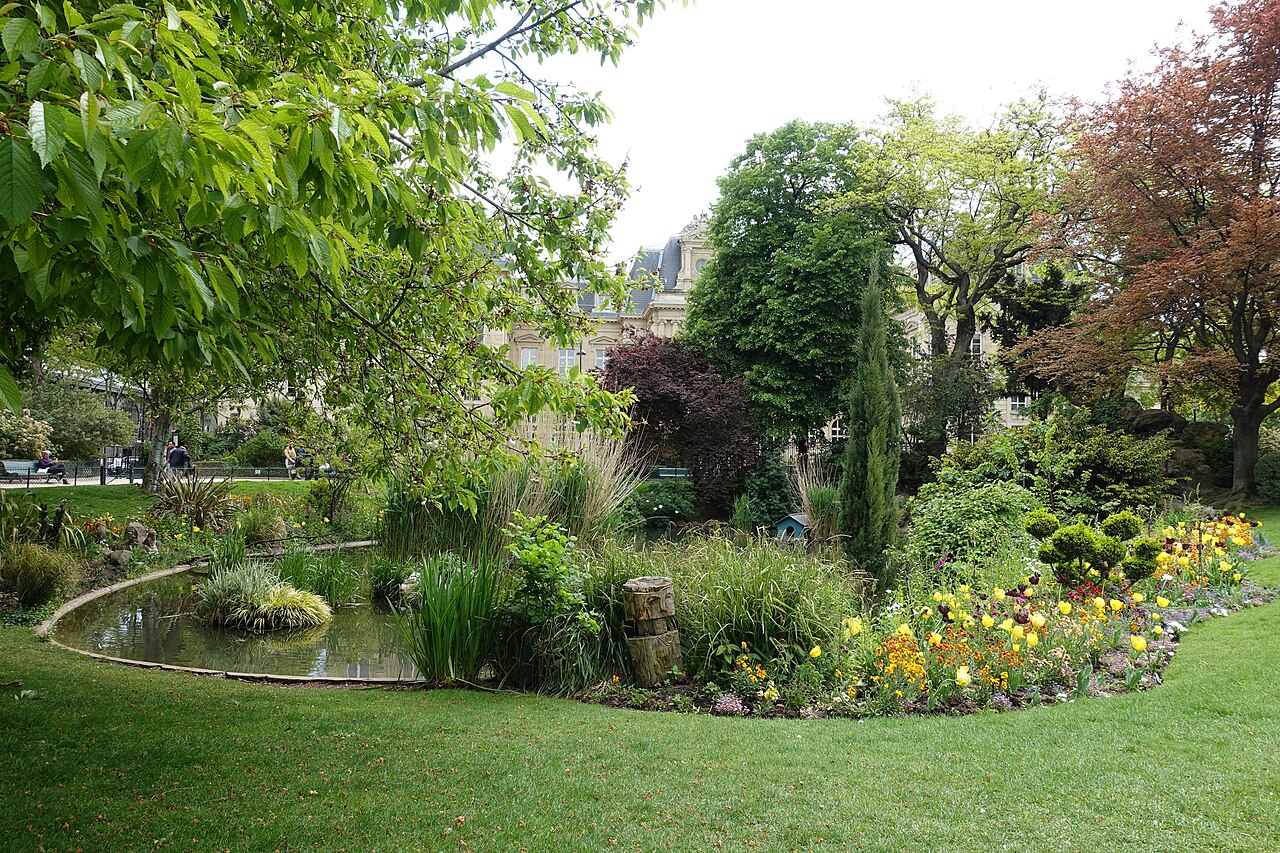 La pelouse du square du Temple, ses massifs fleuris et sa mare bordée de plantes d'eau au printemps