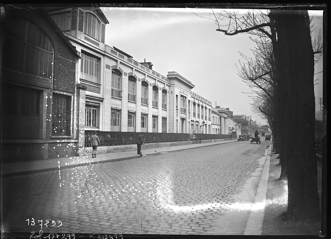 Les bâtiments de l'usine Citroën du quai de Javel en mai 1929, rue pavée et arbres, photographie de l'agence Rol