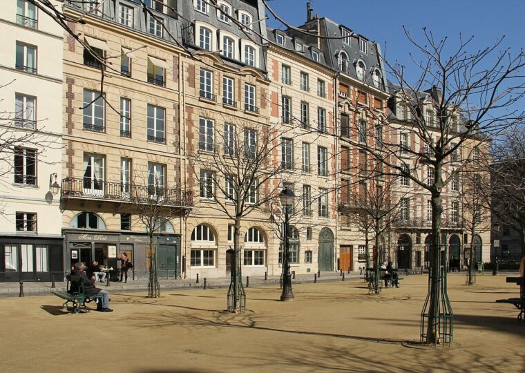 Les façades de brique et pierre de la place Dauphine sous le soleil, bancs et jeunes arbres
