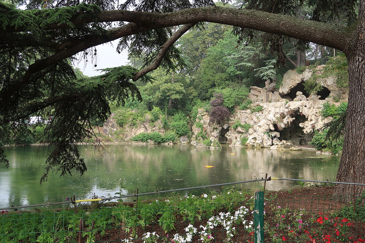 La Grande Cascade du bois de Boulogne, ses rochers et son plan d'eau vus sous les branches du cèdre du Liban qui la borde