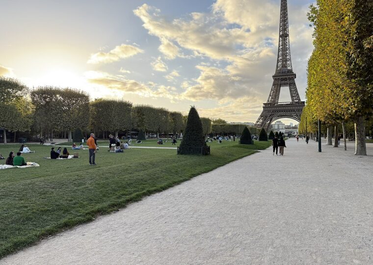 La grande pelouse du Champ-de-Mars, son allée de gravier bordée d'arbres taillés et la tour Eiffel dans l'axe
