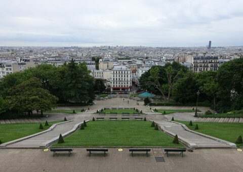 Les pelouses en terrasses du square Louise-Michel vues d'en haut, avec les toits de Paris à l'horizon