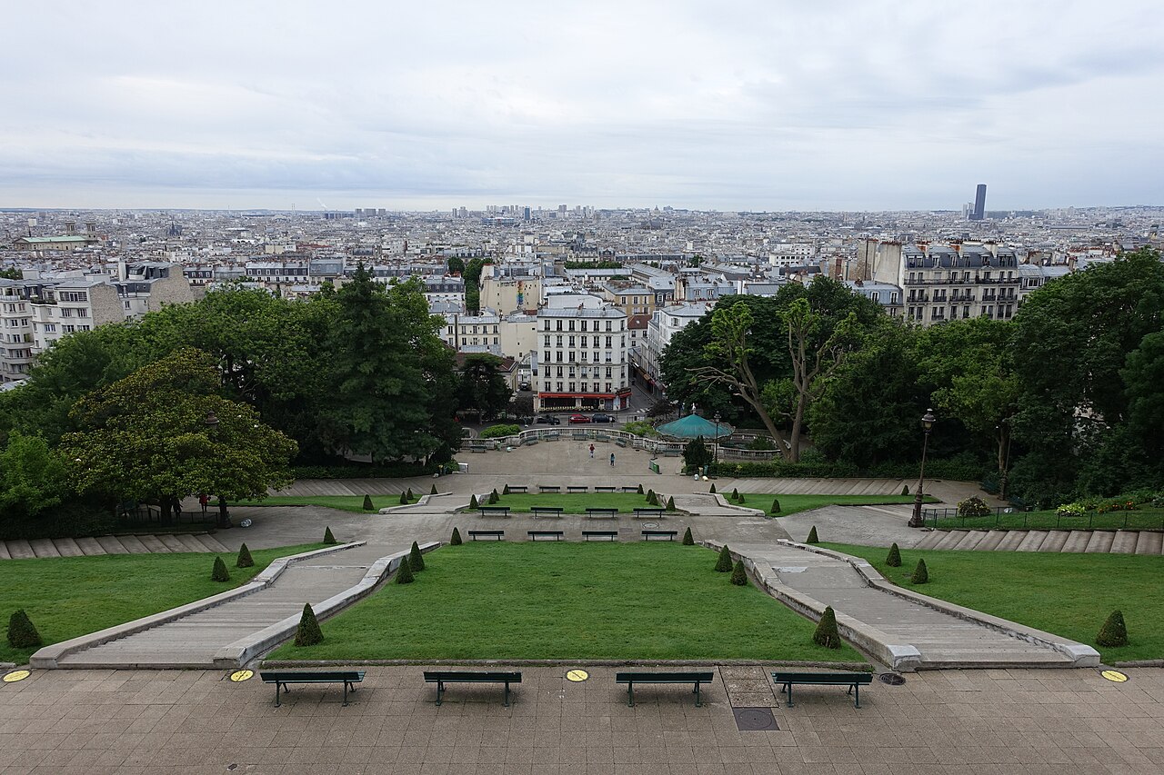Les pelouses en terrasses du square Louise-Michel vues d'en haut, avec les toits de Paris à l'horizon