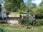 Les assises de pierre de la tour de la Liberté, vestige de la Bastille remonté au square Henri-Galli, au milieu des fleurs