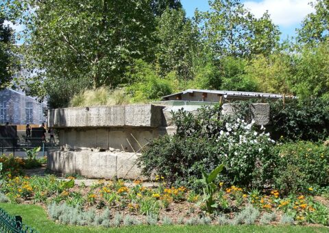 Les assises de pierre de la tour de la Liberté, vestige de la Bastille remonté au square Henri-Galli, au milieu des fleurs