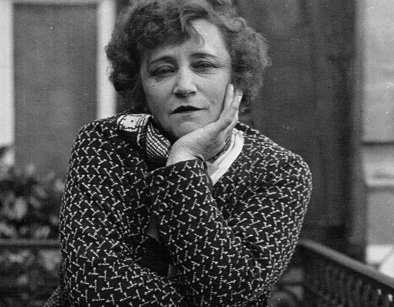 Colette accoudée à un balcon, la joue appuyée sur la main, en 1932
