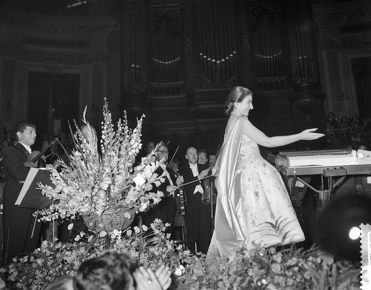 Maria Callas saluant sur la scène du Concertgebouw d'Amsterdam, entre les gerbes de fleurs, le 11 juillet 1959
