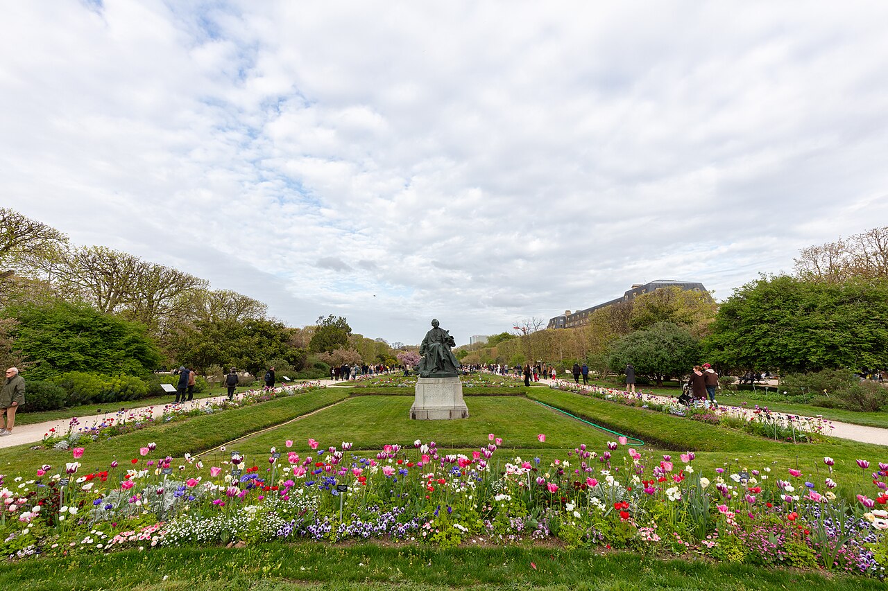 Les parterres fleuris du Jardin des Plantes au printemps, avec une statue au centre de la grande perspective