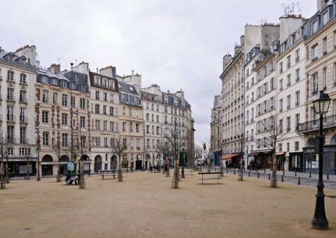La place Dauphine sous un ciel gris, bancs et réverbère, décor du roman Nadja