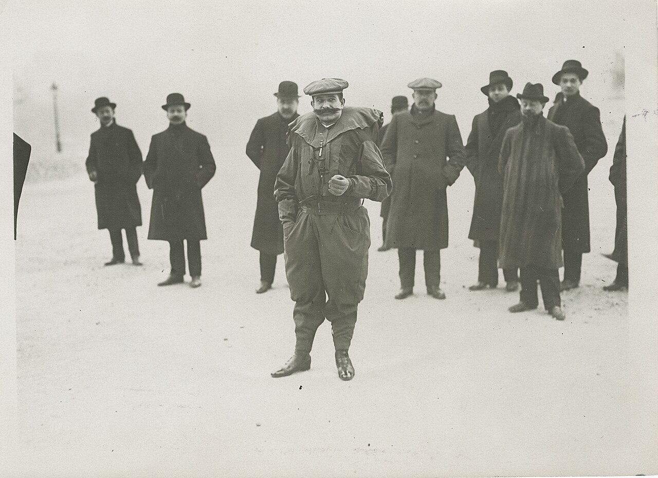 Franz Reichelt en costume parachute devant un groupe de témoins en pardessus