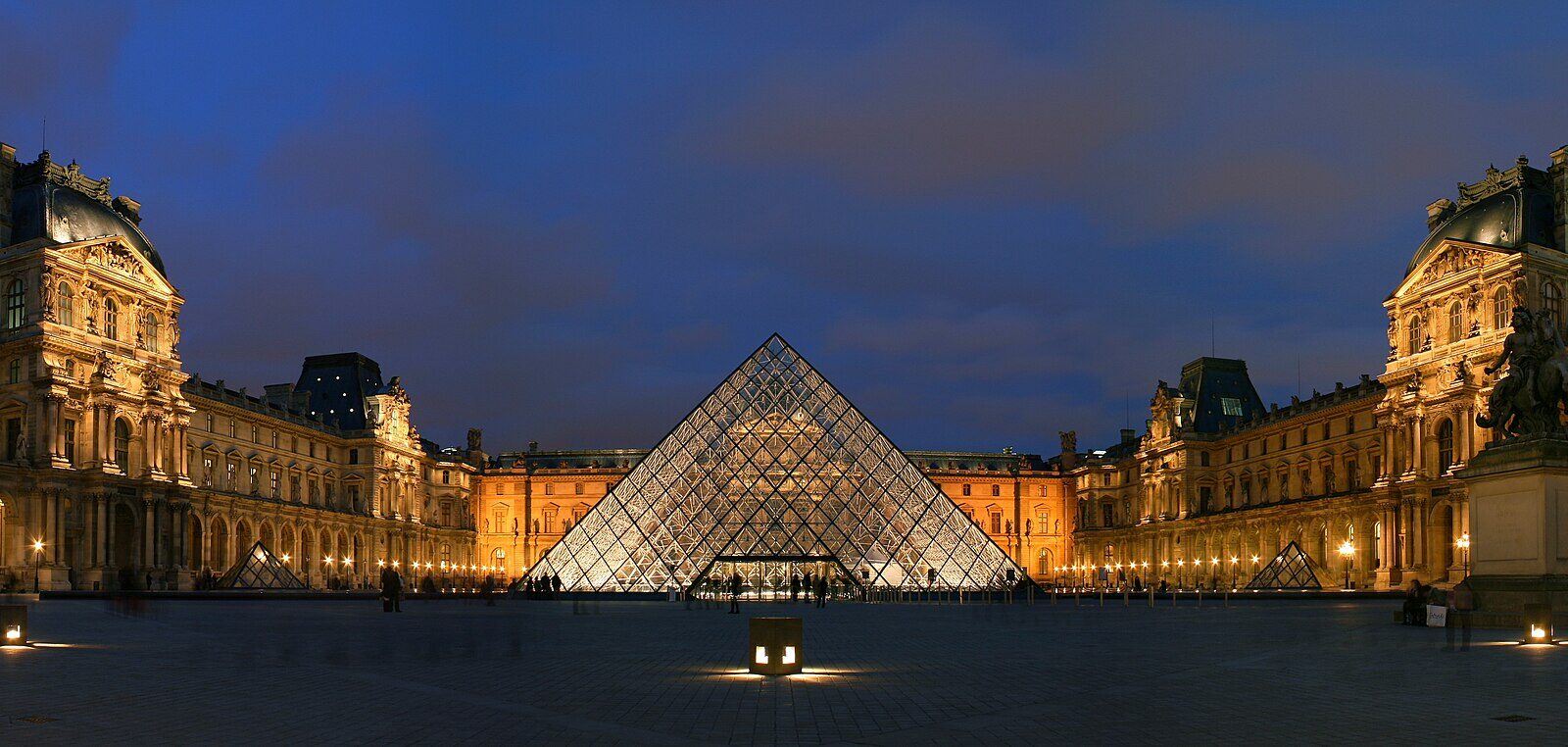 La pyramide du musée du Louvre illuminée, cour Napoléon à la nuit tombée